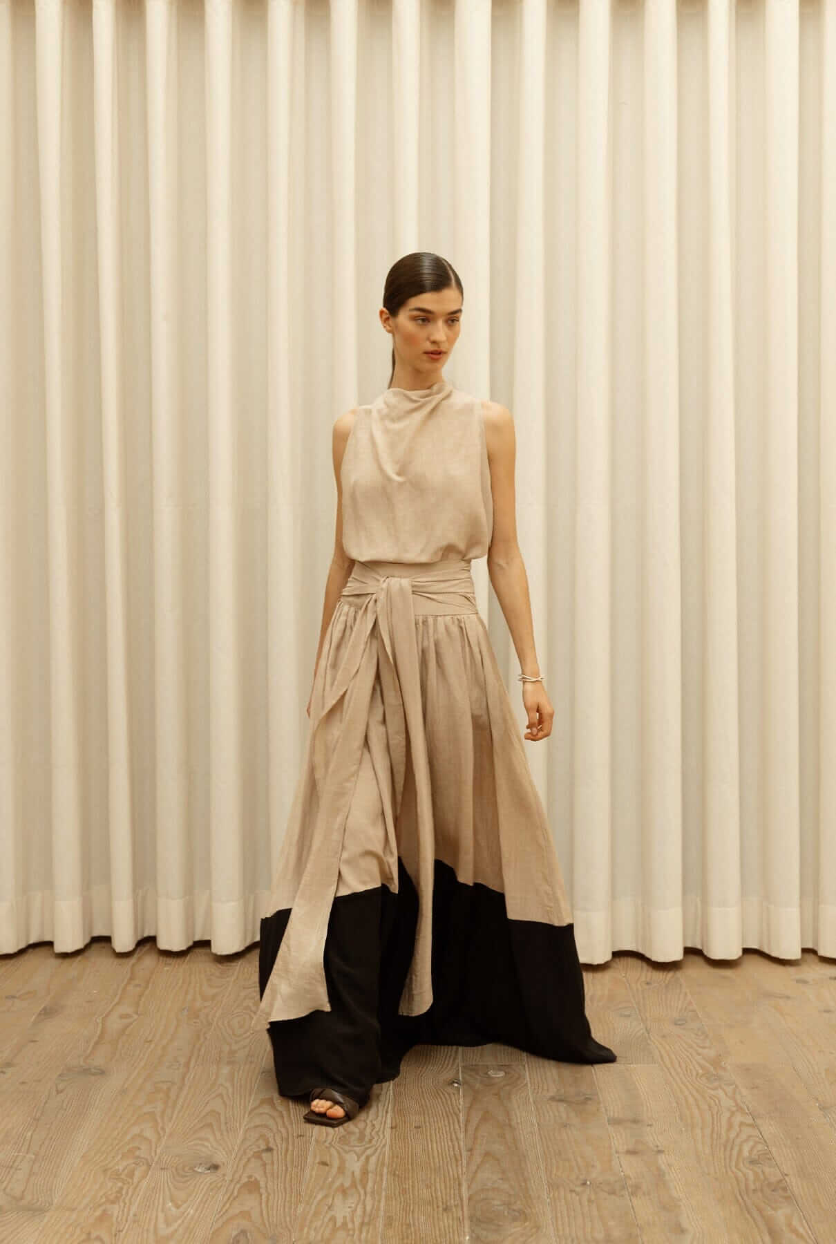 Stylish woman wearing a unique dress with a wrap design, showcasing elegant fashion in tops t-shirts collection.